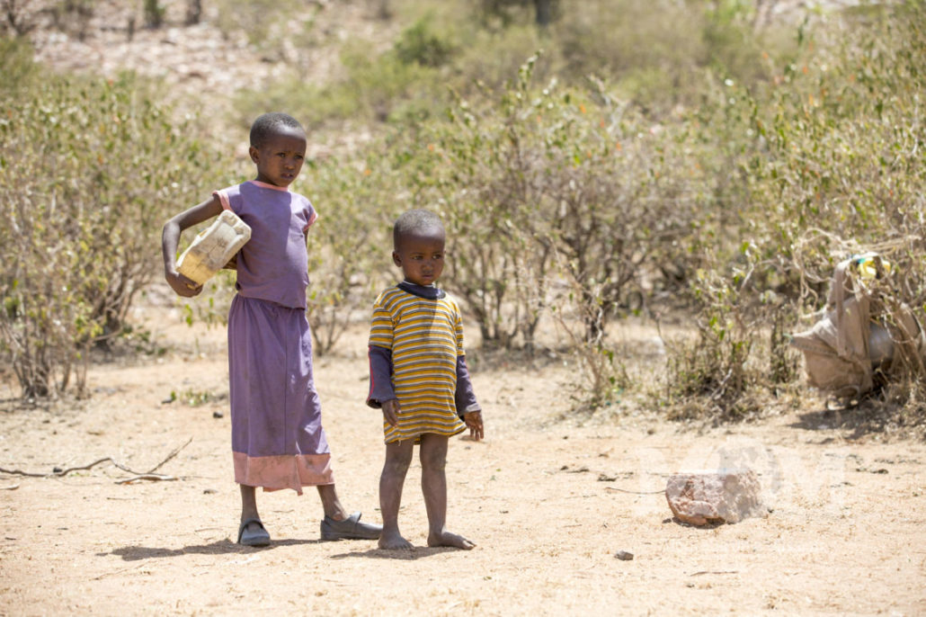 Children often follow their mothers along to help fetch water. Carrying smaller containers and learning how to balance the heavy loads.