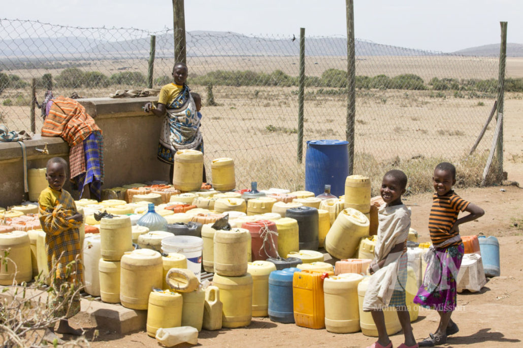 Women often have to walk long distances to collect water for their families and arrive to a crowded source and must wait in line for the chance to fill their jerry cans.